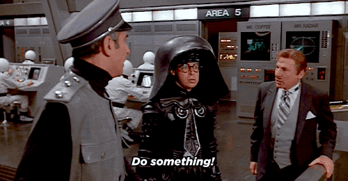 Animated gif from the movie Space Balls with characters giving orders to "Do something," representing the idea that Google wants control over advertisers' Google Ads campaigns and budgets.